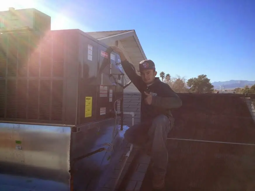 HVAC technician performing AC Tune-Up on a rooftop unit in Northville